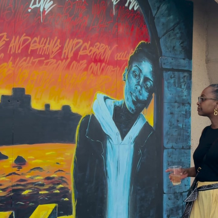 Someone stopping to look at a mural on the seafront